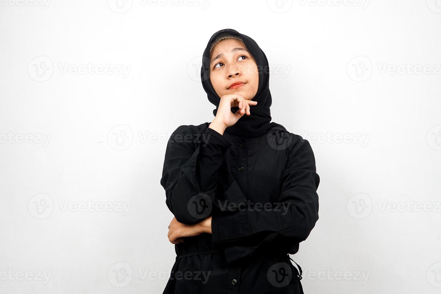 vacker asiatisk ung muslimsk kvinna som tänker, letar efter idéer, letar efter lösningar på problem, med händer som håller hakan, isolerad på vit bakgrund foto