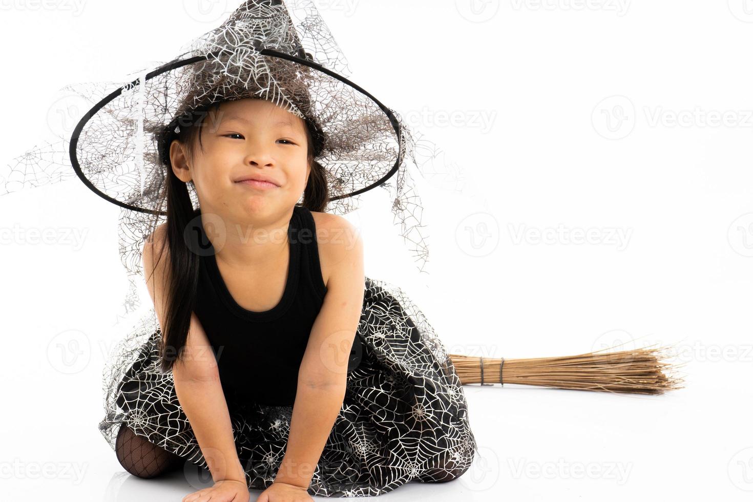 porträtt asiatisk liten flicka klädd i söt häxa för halloween kostym foto