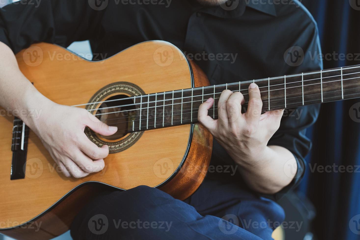 närbild av musiker som spelar gitarr foto