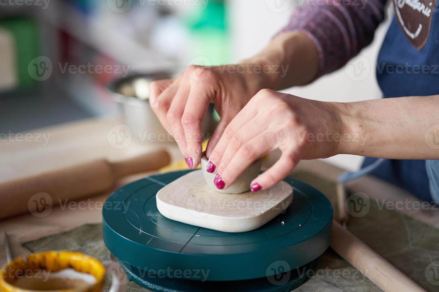 kvinna som gör keramik, händer närbild, suddig bakgrund, fokus på krukmakare, palmer med keramik foto