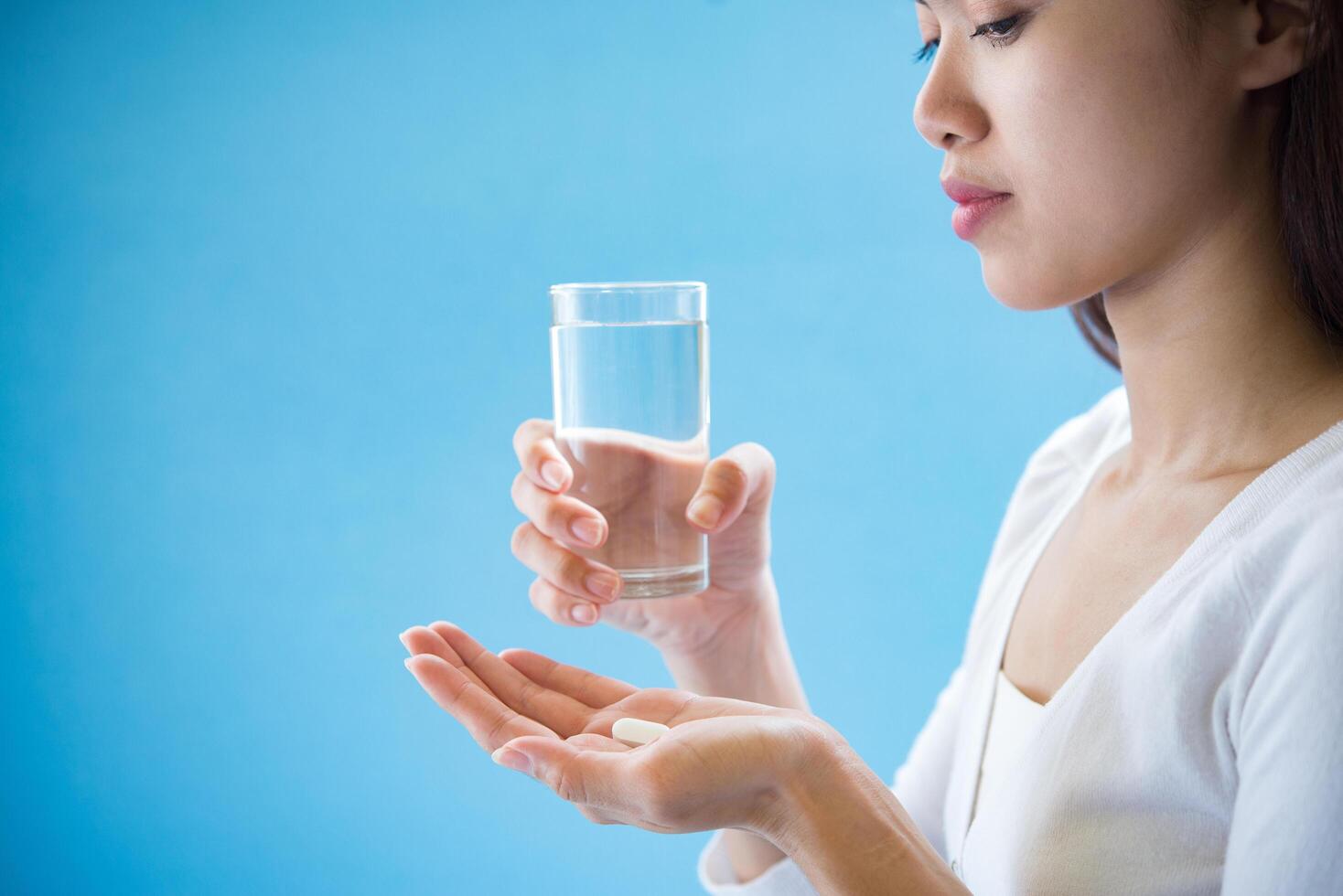 kvinnans hand häller medicinpillerna ur flaskan foto