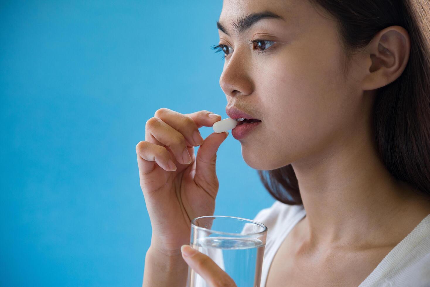 ung kvinna som tar medicin piller efter läkare order foto