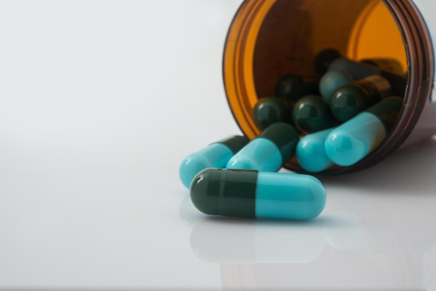 medicinska piller som rinner ut ur en vältad från pillerflaska foto
