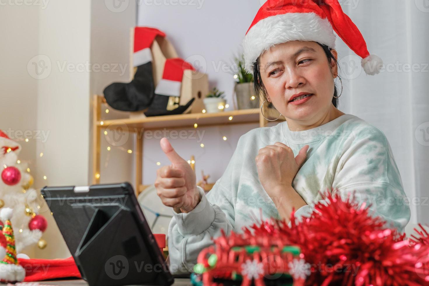 asiatisk kvinna fira nyår och julfest med surfplatta videosamtal vänner hemma foto