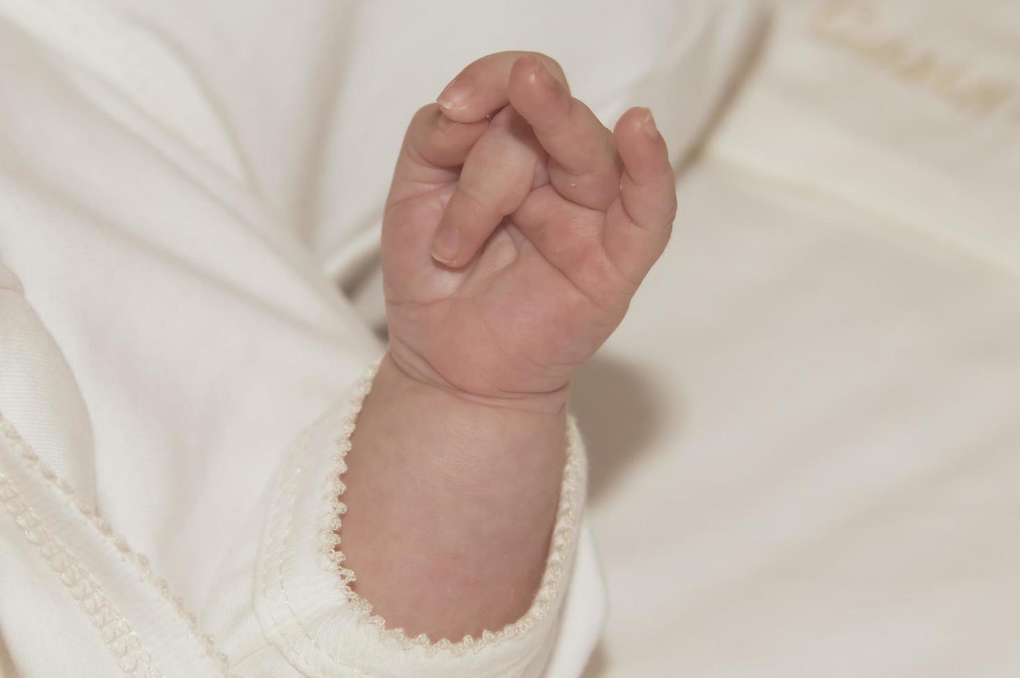 handen av en baby i kyrkan vid dopceremonin. religion. närbild. foto