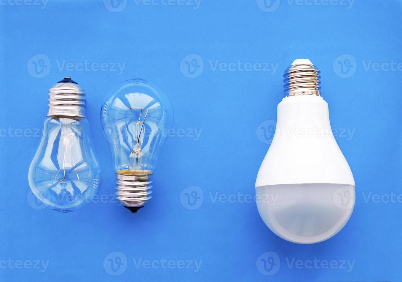 energisnål lampa med glödlampor i rad på blå bakgrund. konceptet att spara energi. foto