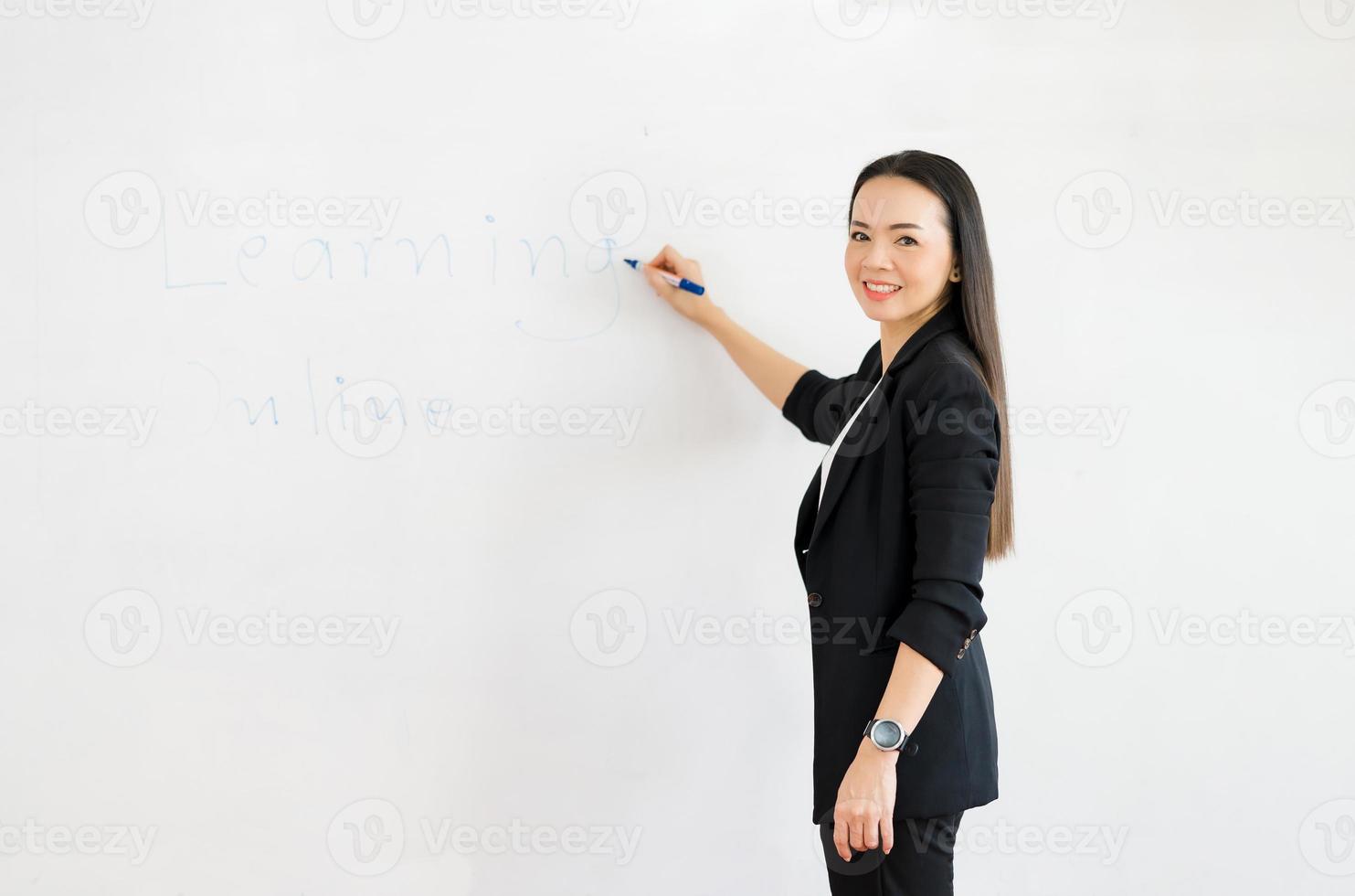 en ung asiatisk lärare står framför ett klassrum på universitetet. foto