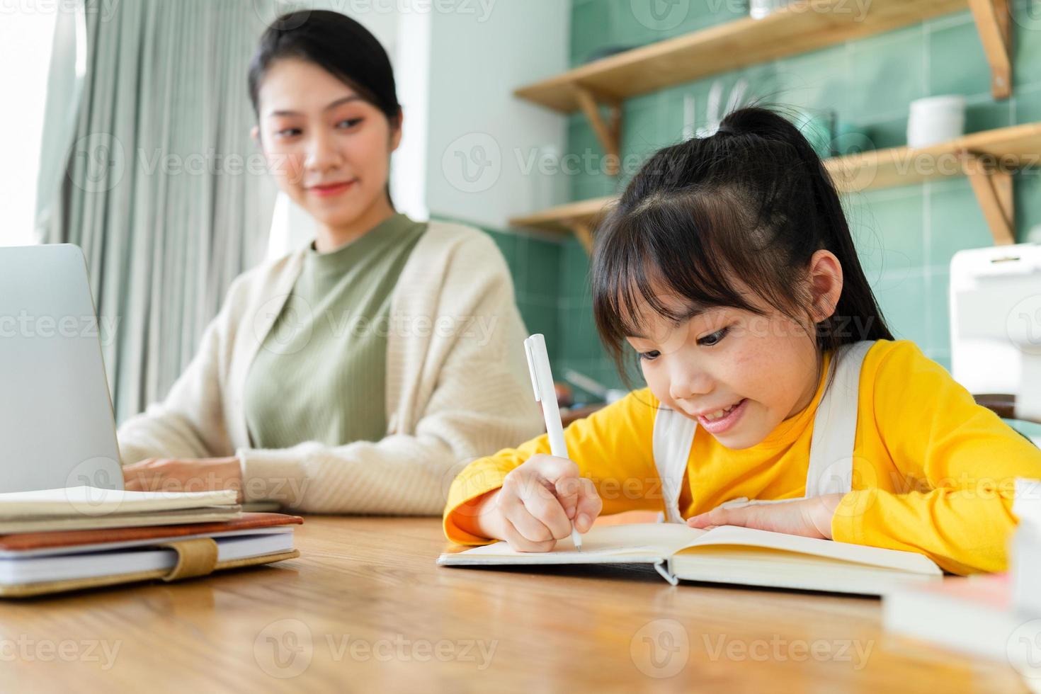 asiatisk mor och dotter som studerar tillsammans hemma foto