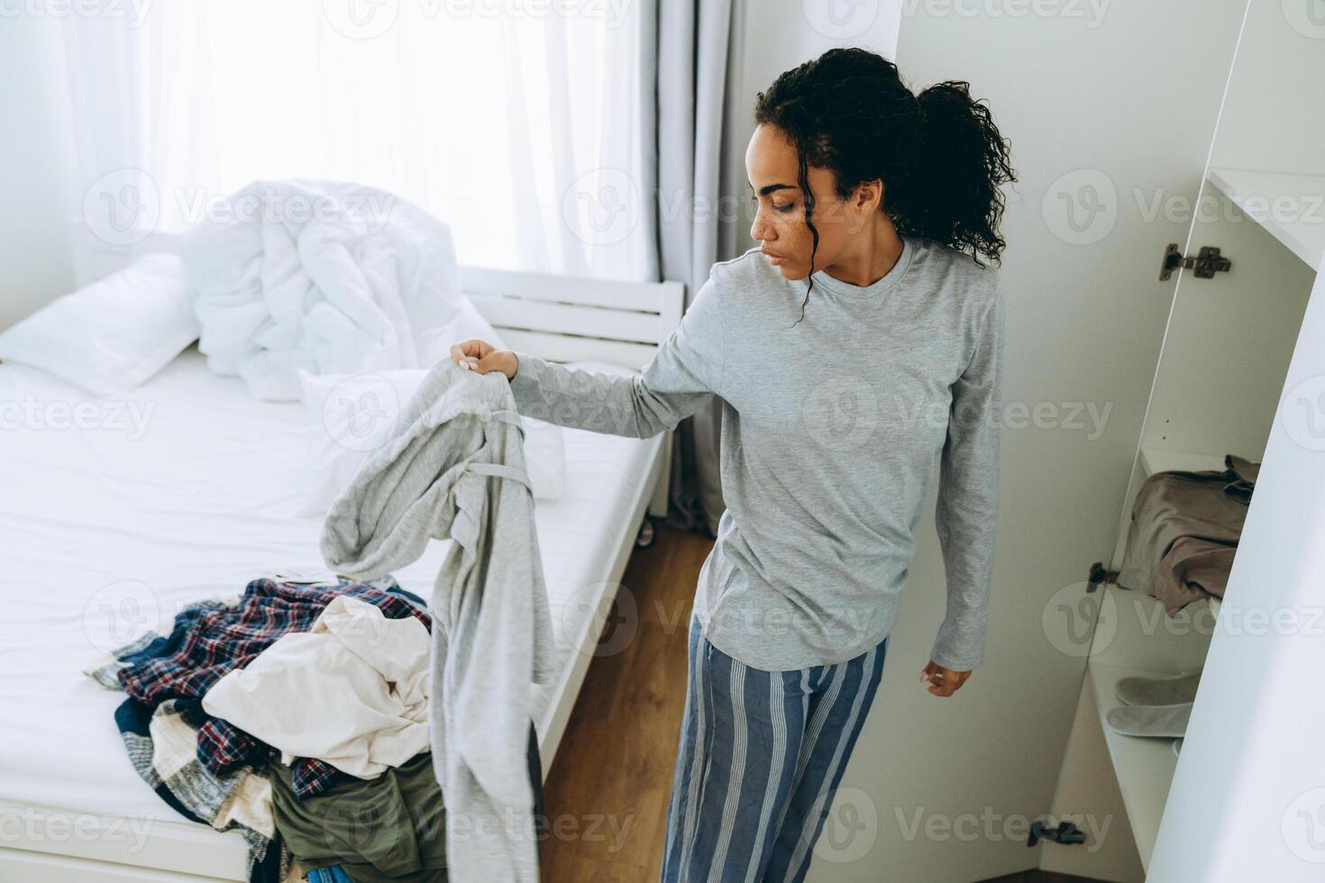 afrikansk trött kvinna drar ut saker ur garderoben foto