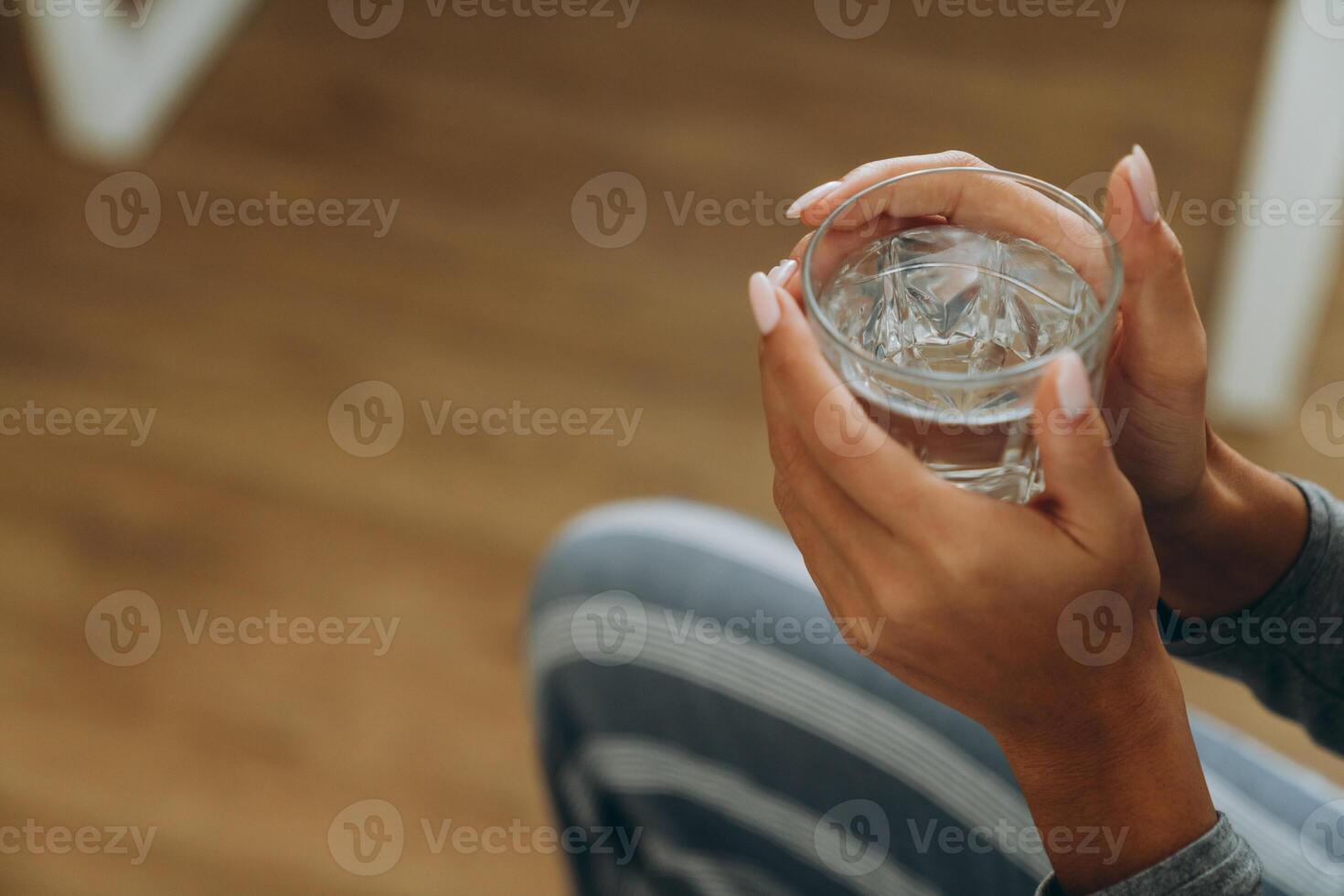 ung svart kvinna dricksvatten under tiden hemma foto