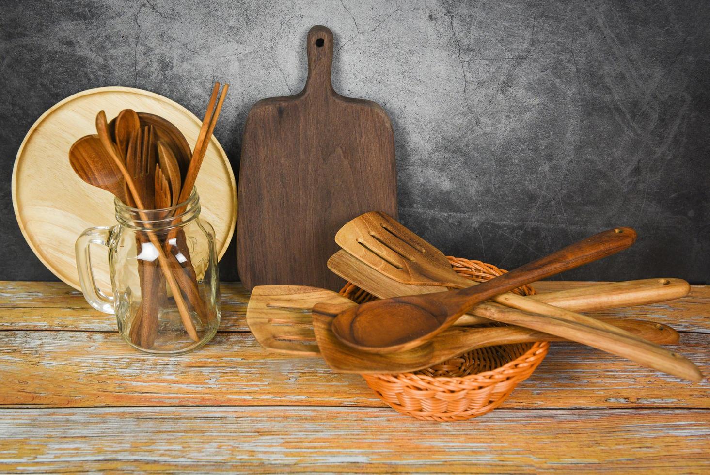 naturliga köksredskap träprodukter köksredskap bakgrund med sked gaffel ätpinnar tallrik skärbräda objekt redskap träkoncept foto