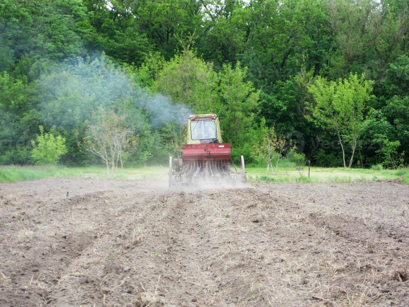 plöjd åker med traktor i brun jord på öppen natur foto