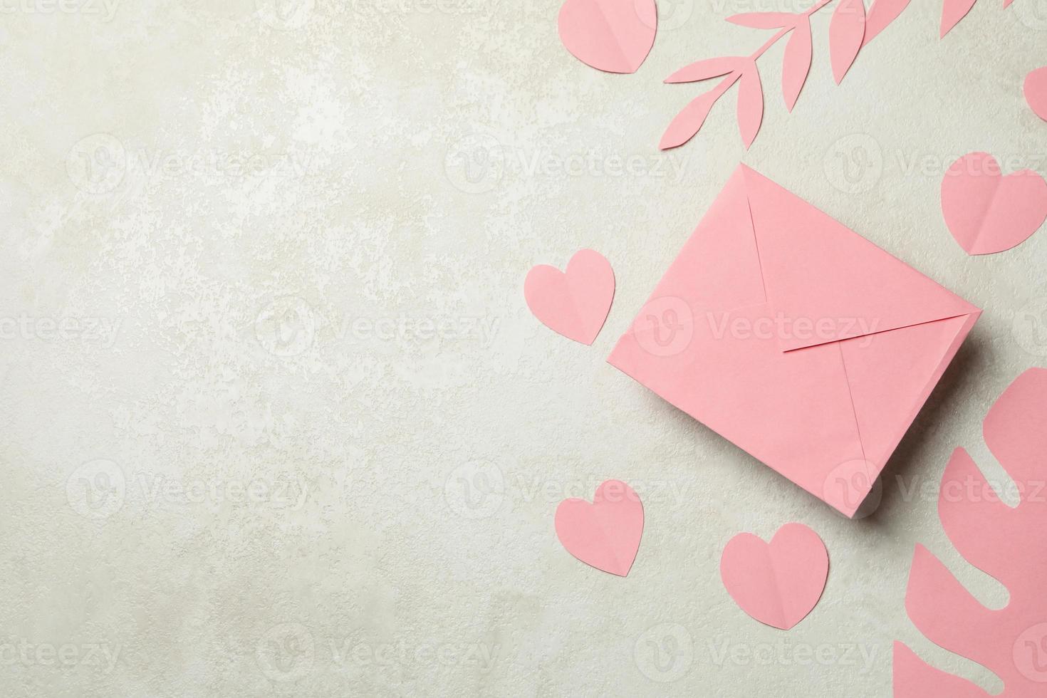 kuvert, pappersblad och hjärtan på vit texturerad bakgrund foto