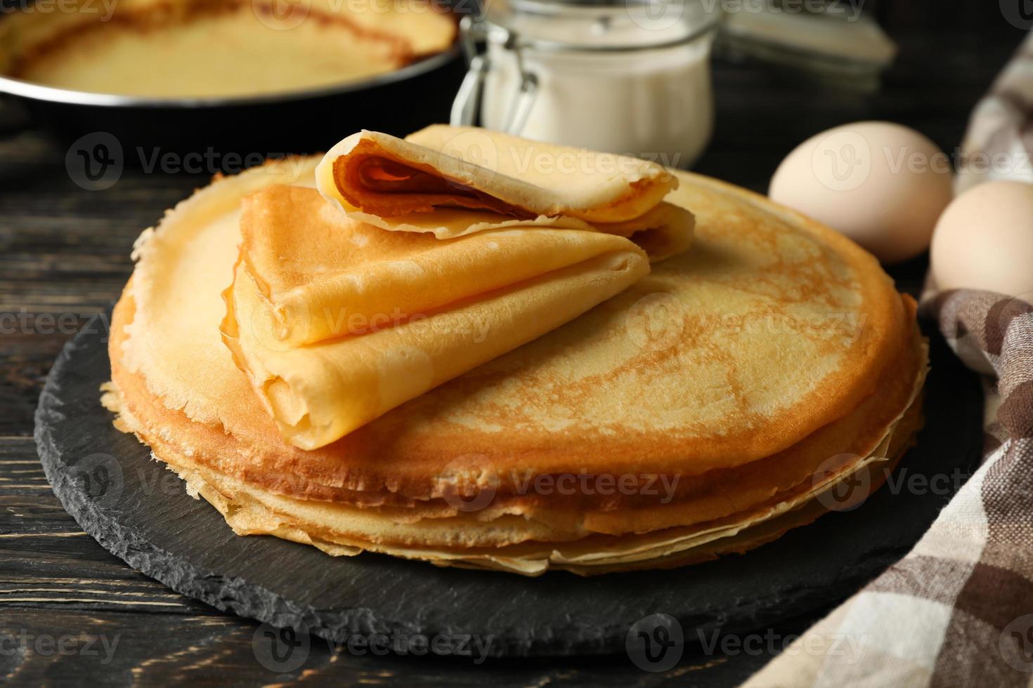 begreppet välsmakande frukost med tunna pannkakor på träbord foto