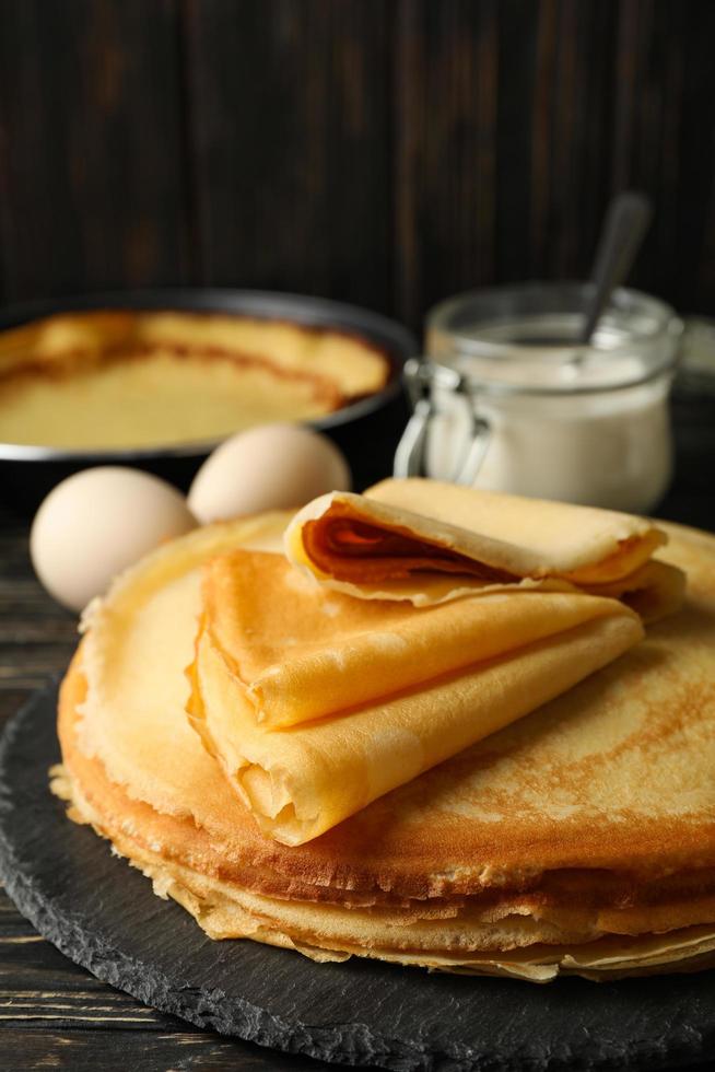 begreppet välsmakande frukost med tunna pannkakor på träbord foto