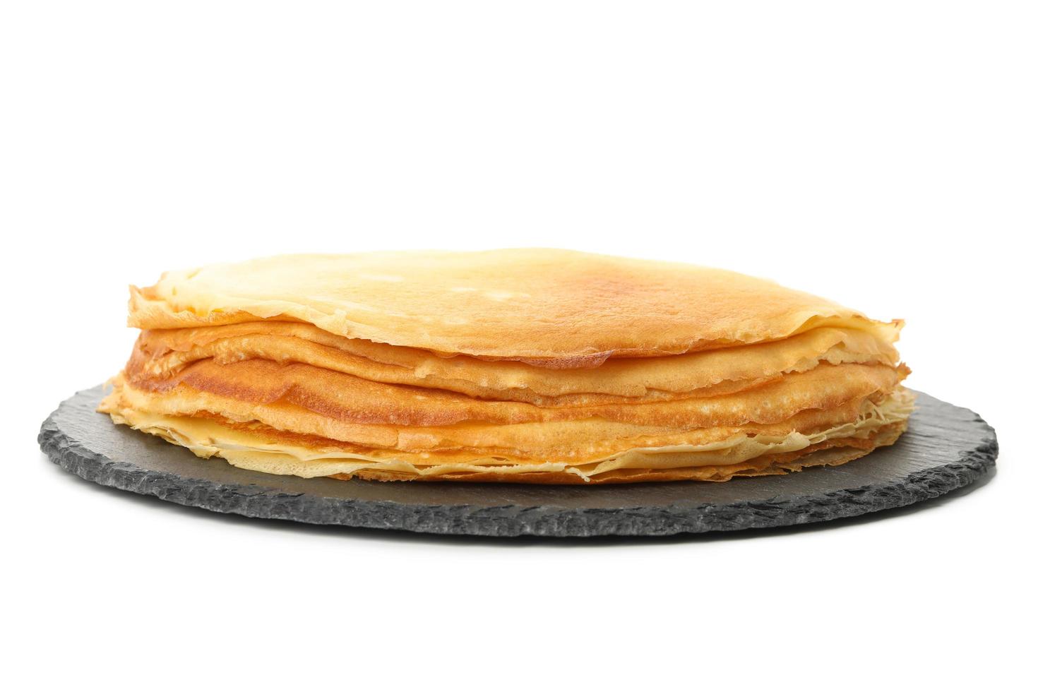 bricka med tunna pannkakor isolerad på vit bakgrund foto