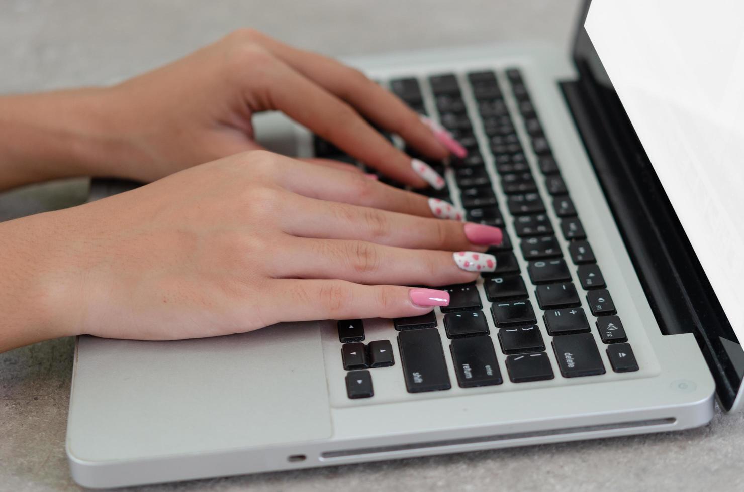 närbild hand kvinna med en bärbar dator tangentbord. konceptteknikaffär foto