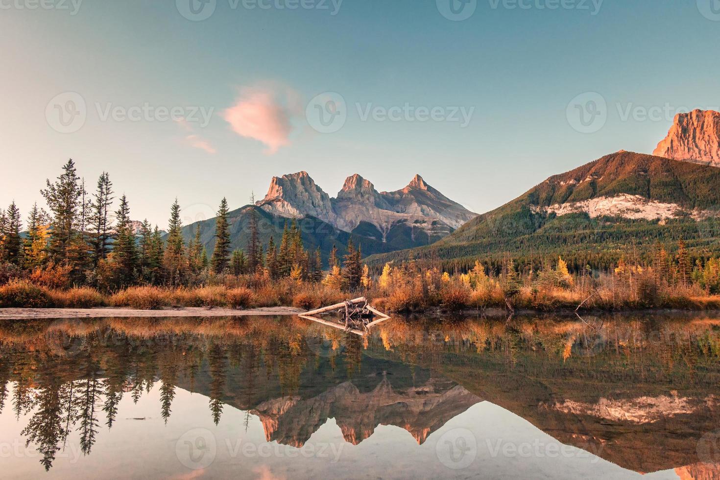 tre systrar berg av klippiga berg reflektion över bowfloden på morgonen vid Canmore, Banff nationalpark foto