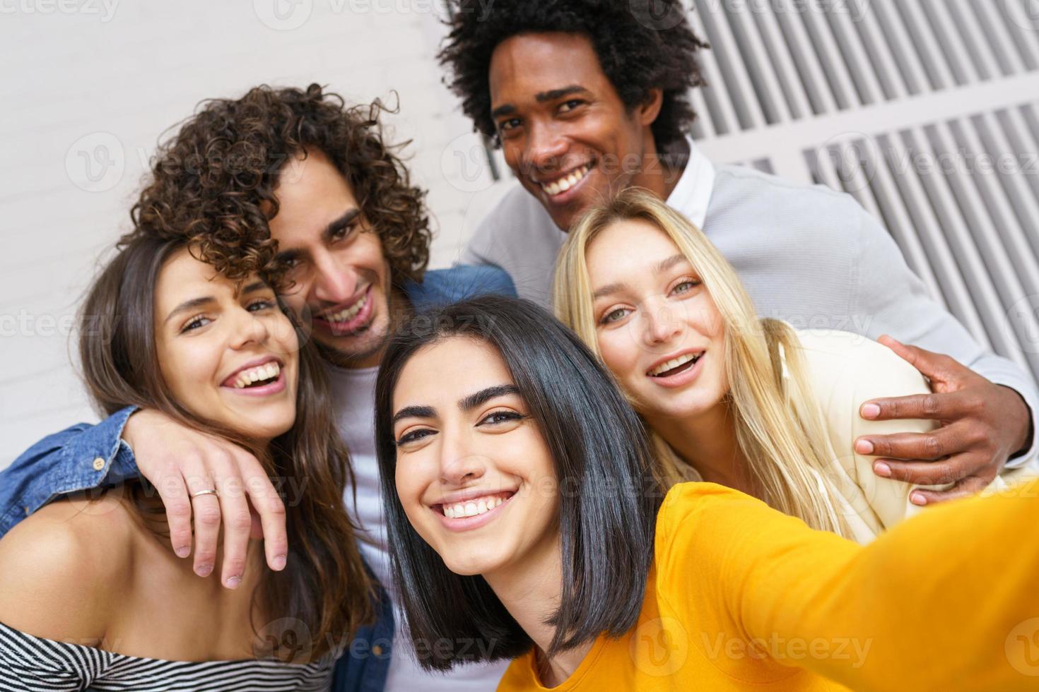 multietnisk grupp vänner som tar en selfie tillsammans medan de har roligt utomhus. foto