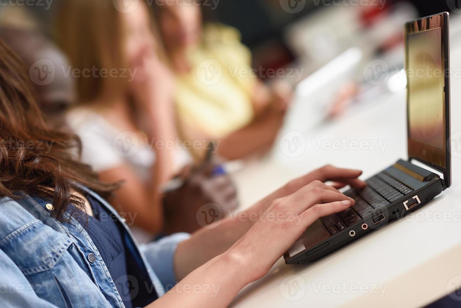 ung kvinna som studerar med bärbar dator på vitt skrivbord. foto