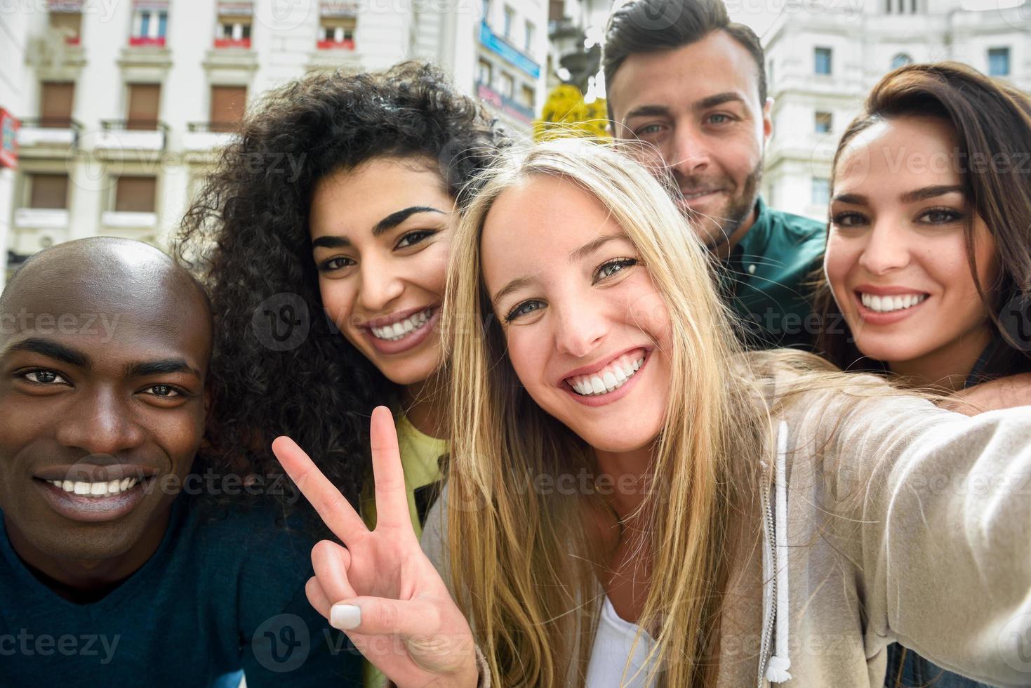 multiracial grupp unga människor som tar selfie foto