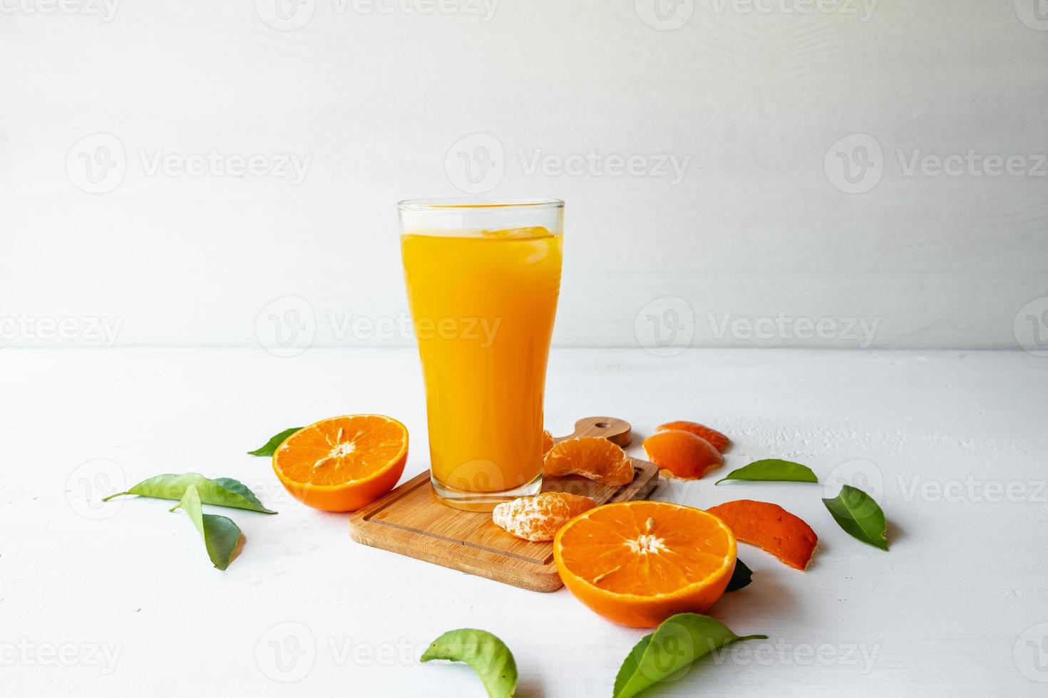 apelsinjuice och färska orange frukter på en vit trä bakgrund foto