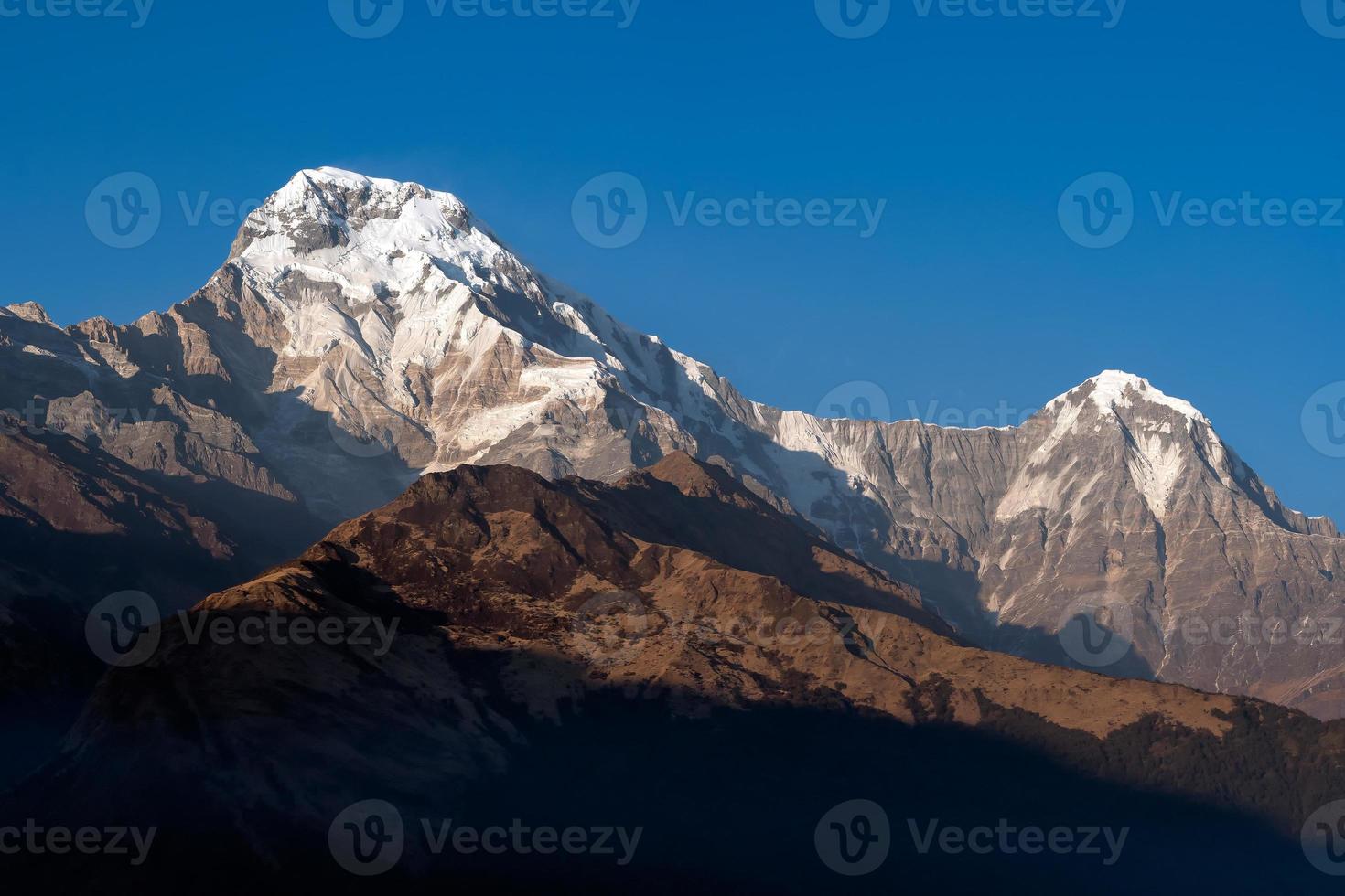 annapurna södra bergstopp med blå himmel bakgrund i nepal foto