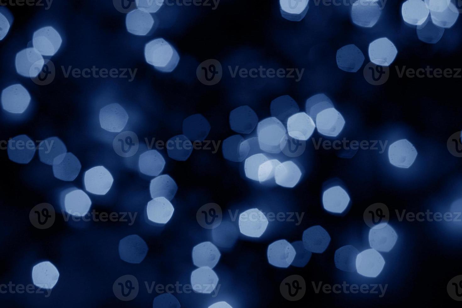 ljusblå oskärpa jul svart bakgrund. abstrakt svart ofokuserad oskärpa ljusa prickar svart. foto