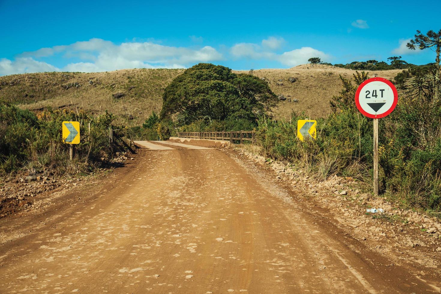 öde grusväg som går genom landsbygdens lågland som kallas pampas med kullar och trafikskyltar nära cambara do sul. en liten lantstad i södra Brasilien med fantastiska naturliga turistattraktioner. foto