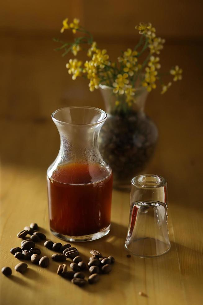 kaffekopp och bönor på träbord foto