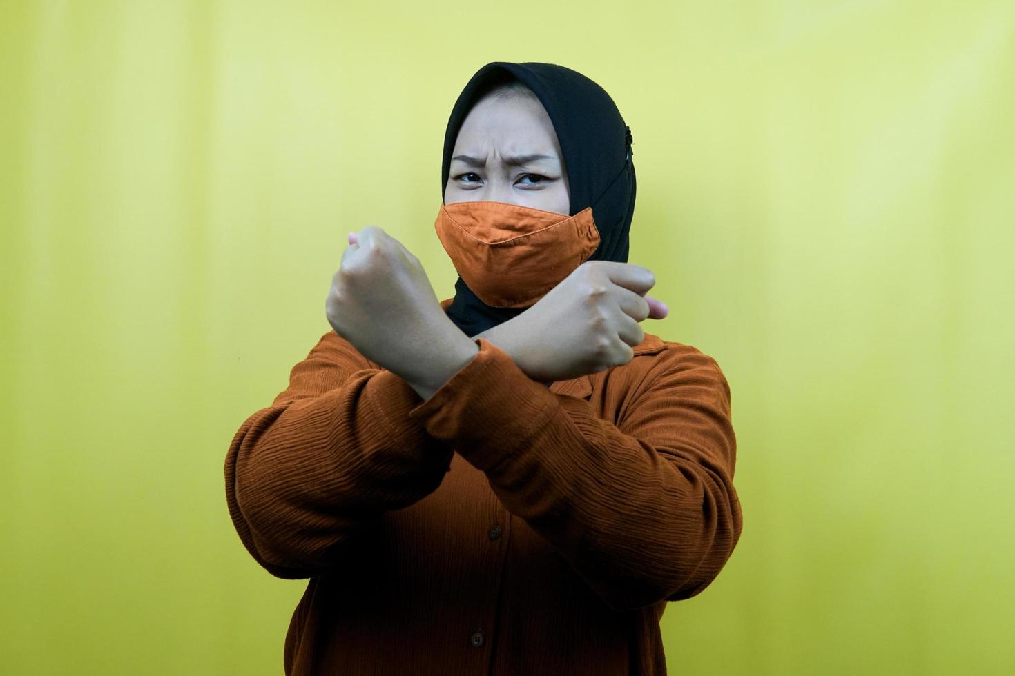 muslimsk kvinna som bär mask, med knuten näve, knytnäveslag, förhindra coronavirus, anda att vinna, isolerad foto