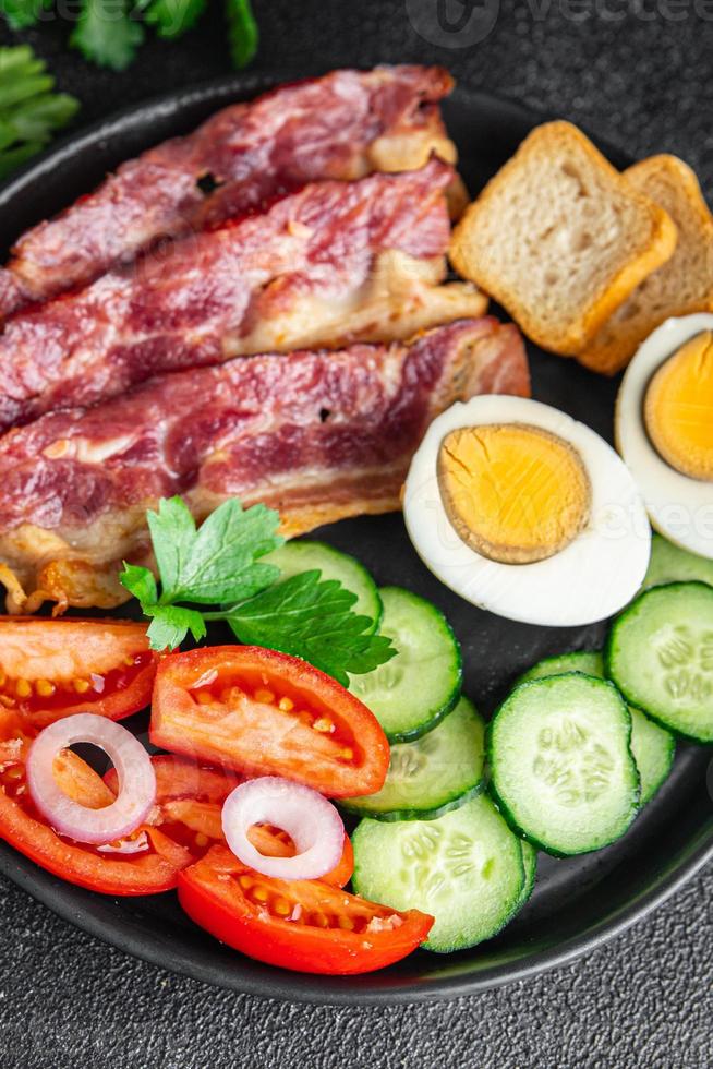 engelsk frukost ägg, bacon, tomat, gurka, rostat bröd foto