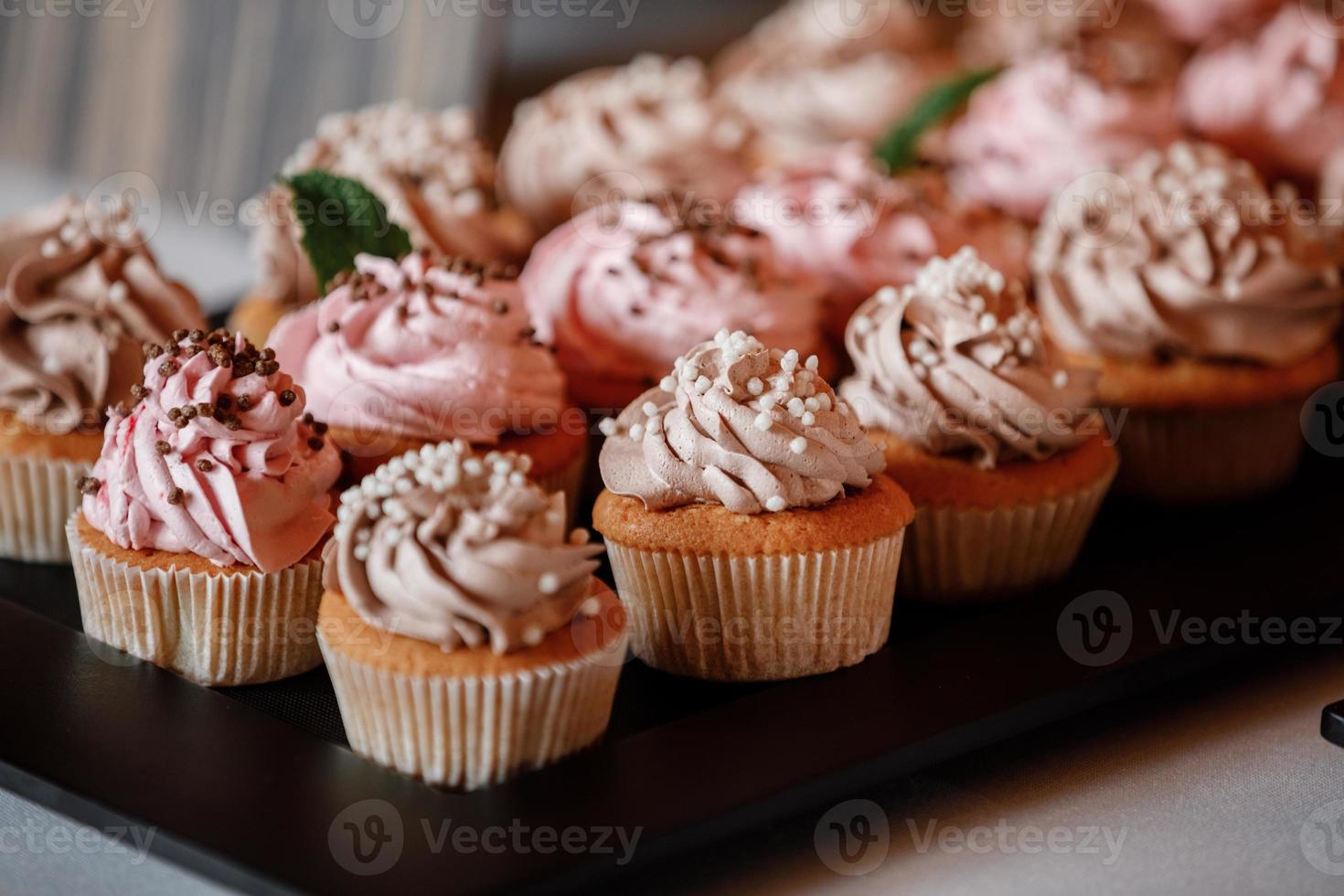 cupcakes med lockar av krämig jordgubbsglasyr foto