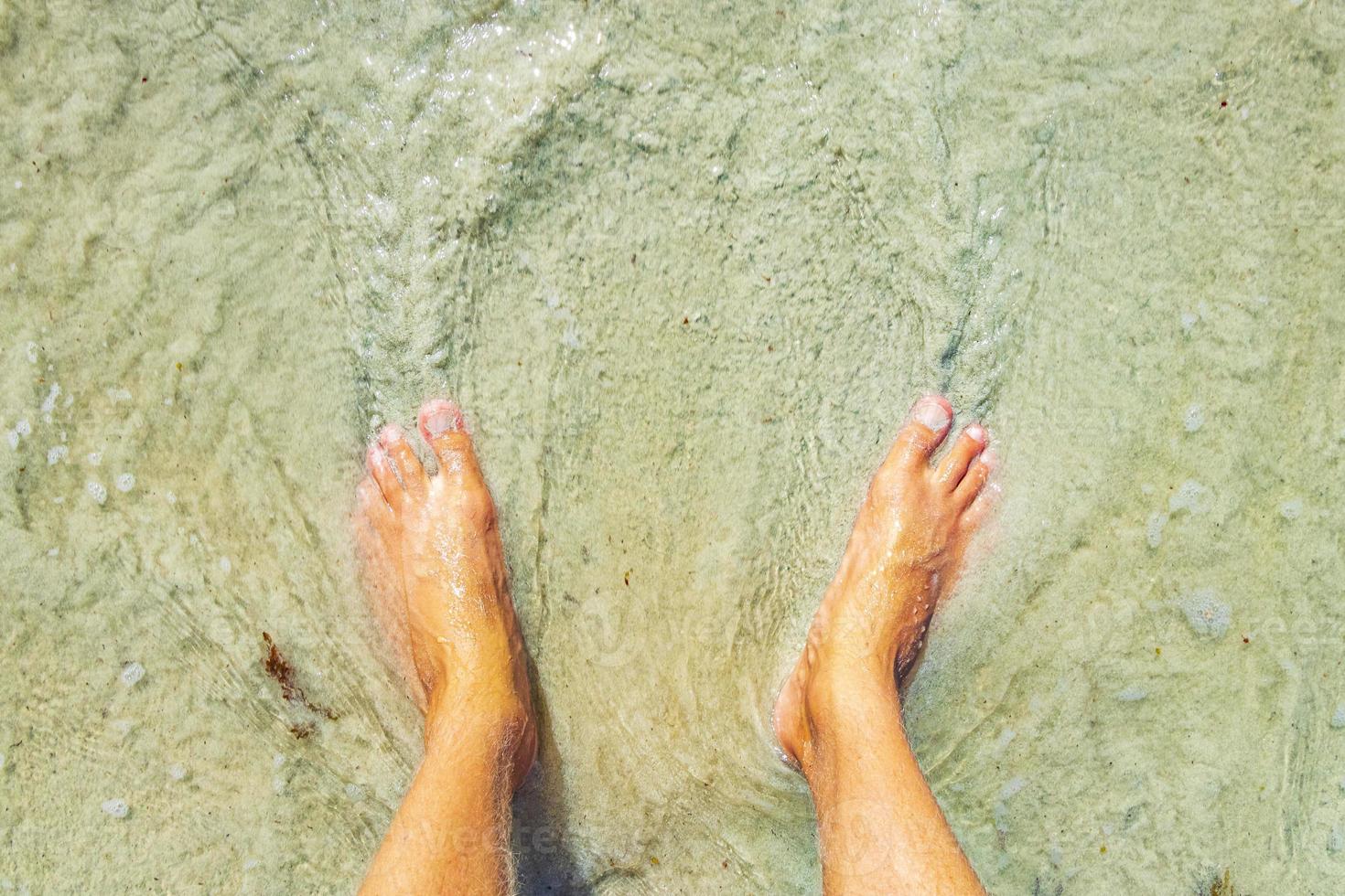 fötter i vatten och sandstrand playa del carmen mexico. foto