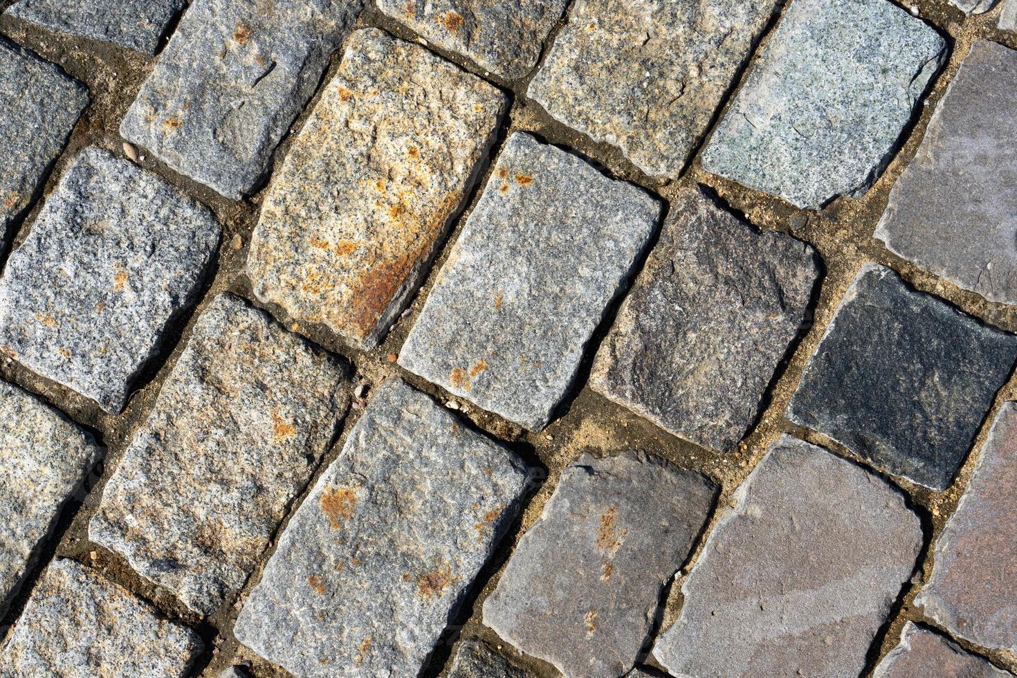 strukturen på stenbeläggningen. bakgrund av granit kullersten trottoaren. abstrakt bakgrund av en gammal kullerstensgata närbild. Moskva foto