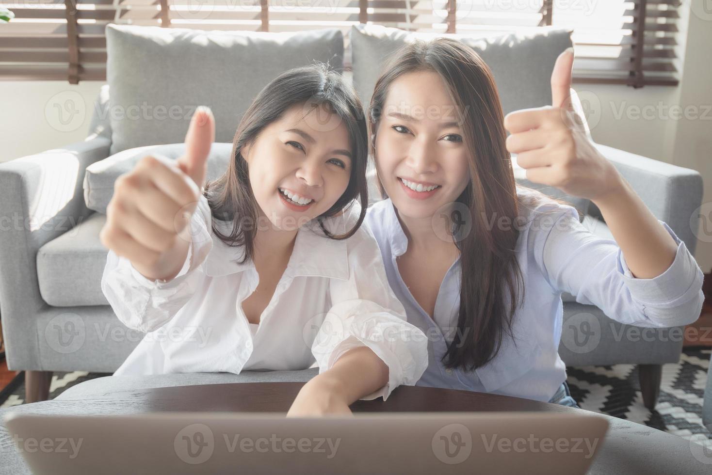 två unga kvinnor använder bärbar dator för att handla online via internet under vistelse säkert hemma foto