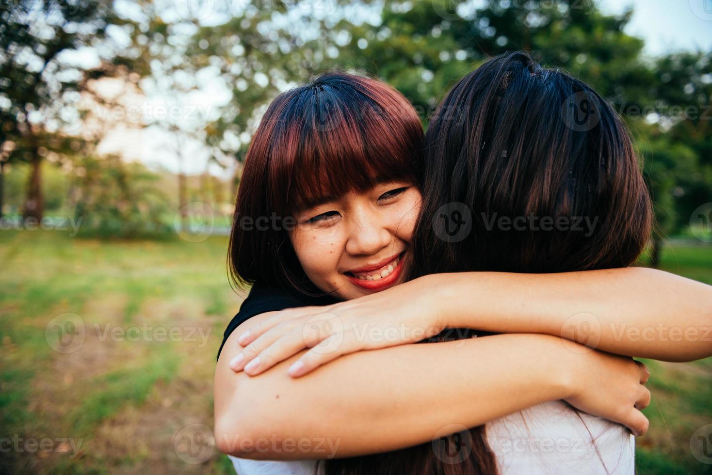hbt lesbiska kvinnor par stunder lycka. lesbiska kvinnor par tillsammans utomhus koncept. lesbiskt par omfamnade tillsammans relation bli kär. två asiatiska kvinnor som har roligt tillsammans i parken. foto