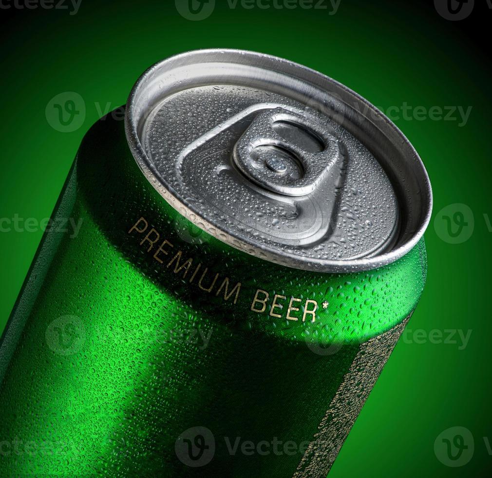 burk öl med droppar vatten i en grön bakgrund med belysning. reklam för öl foto