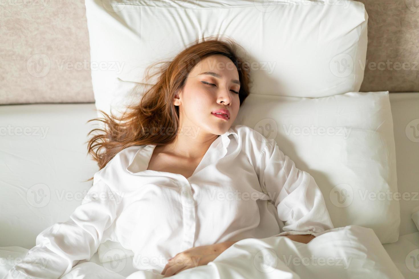 porträtt vacker kvinna som sover på sängen foto