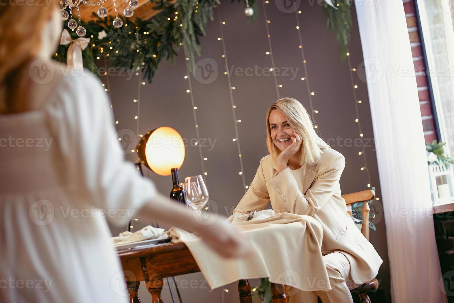 lesbiskt par äter middag på en restaurang. flicka som ger en gåva till sin älskling foto