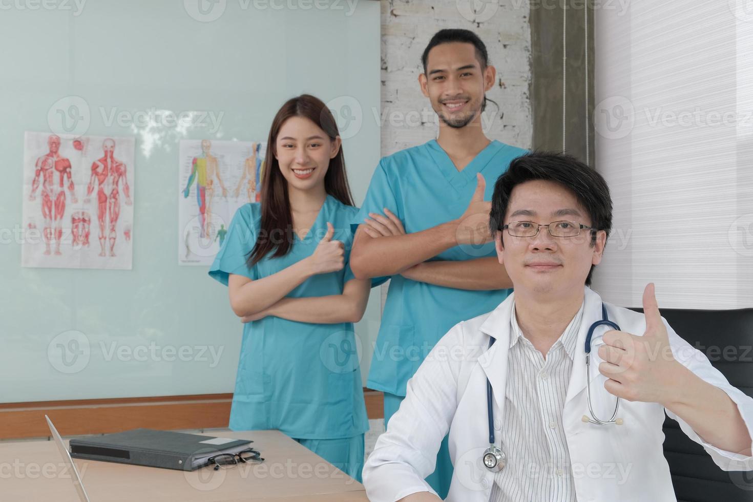 vårdgrupp, porträtt av tre unga läkare av asiatisk etnicitet i uniform med stetoskop, leende och titta på kameran i kliniken, personer som har expertis inom professionell behandling. foto