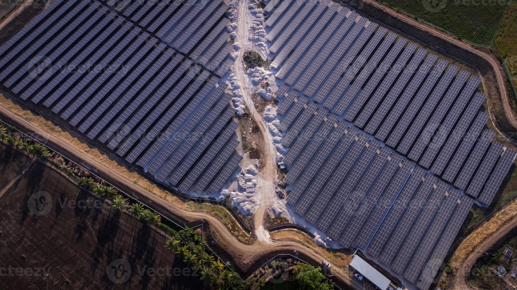 Flygfoto över en solgård som producerar ren energi under kvällen. synlig runt området foto