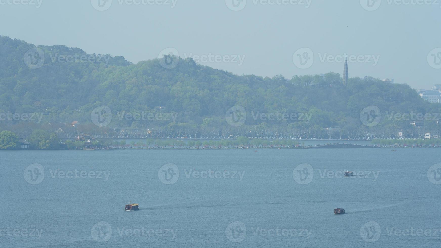 de vackra sjölandskapen i hangzhou-staden i Kina på våren med den fridfulla sjön och de friska gröna bergen foto