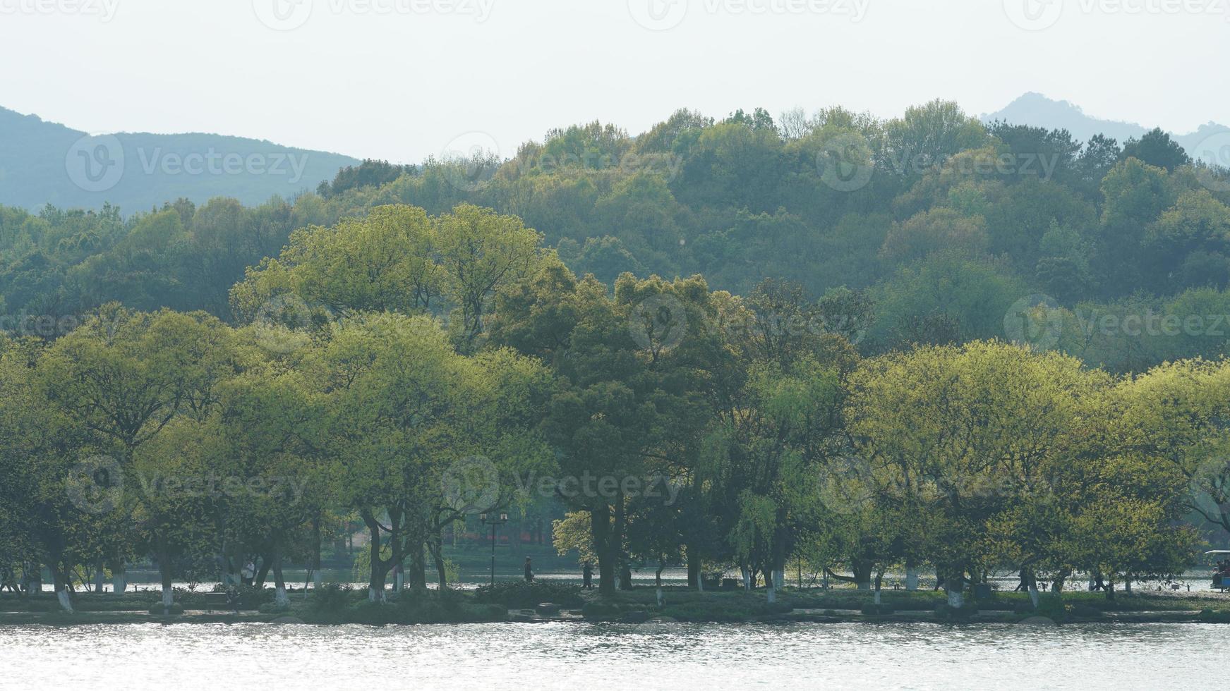 de vackra sjölandskapen i hangzhou-staden i Kina på våren med den fridfulla sjön och de friska gröna bergen foto