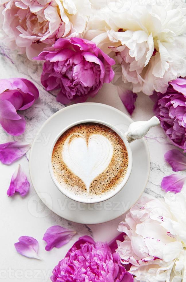 rosa pionblommor och kopp kaffe foto