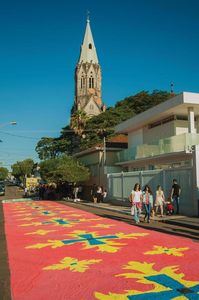 sao manuel, brasilien - 31 maj 2018. människor som går på gatan och beundrar färgglada sandmattor gjorda för firandet av den heliga veckan i sao manuel. en liten stad på landsbygden i delstaten sao paulo. foto