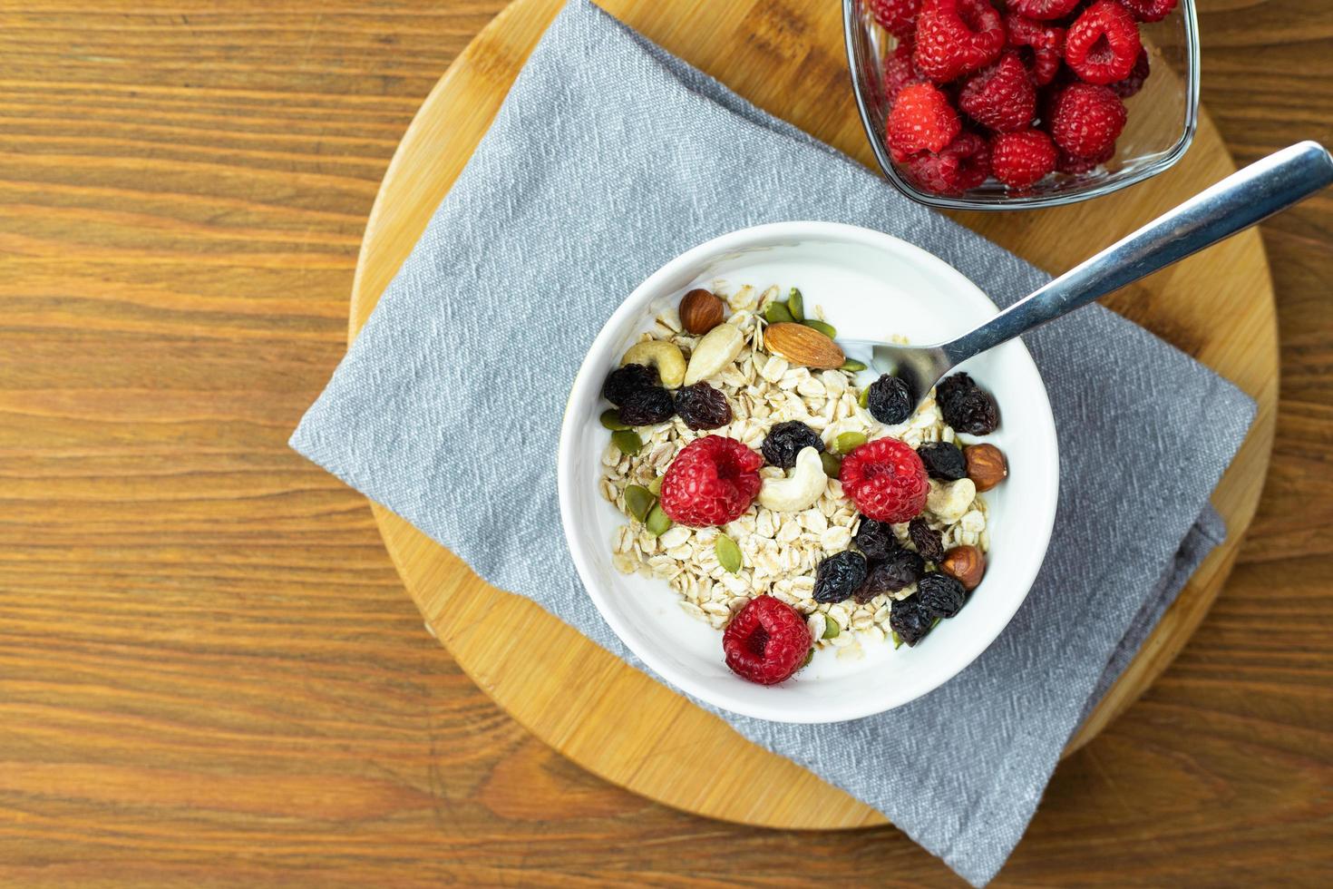 havregryn med hallon, nötter och naturell yoghurt. nyttig frukost. foto