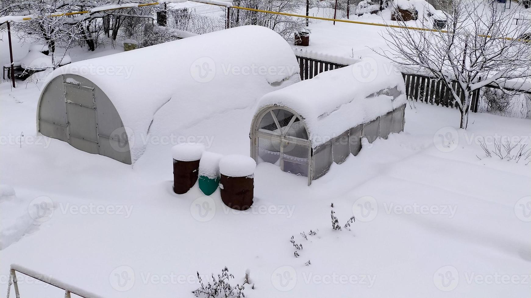 växthusen var täckta av snö. utsikt från ovan. grönsaksträdgård på vintern. pittoreska snöiga vinterlandskap. foto