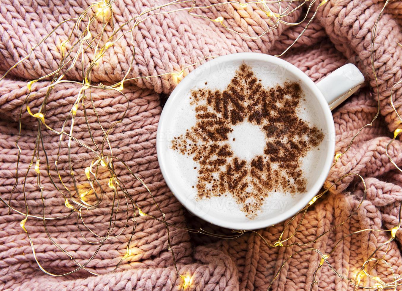 kaffe med snöflingamönster på en varm stickad tröja foto