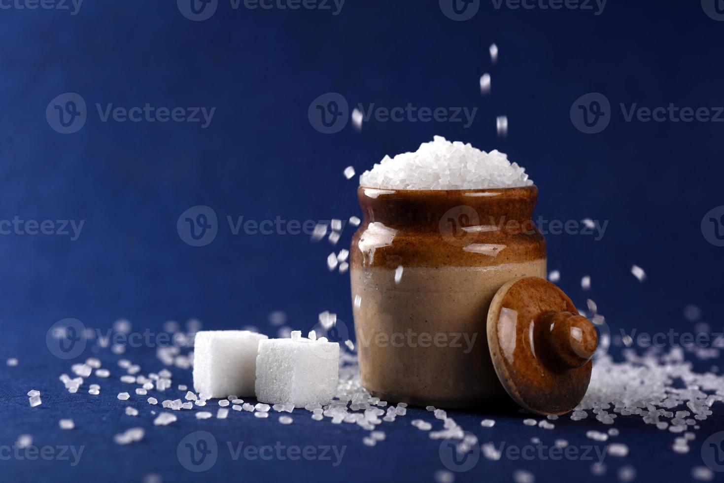 socker. vitt strösocker och raffinerat socker på en blå bakgrund foto